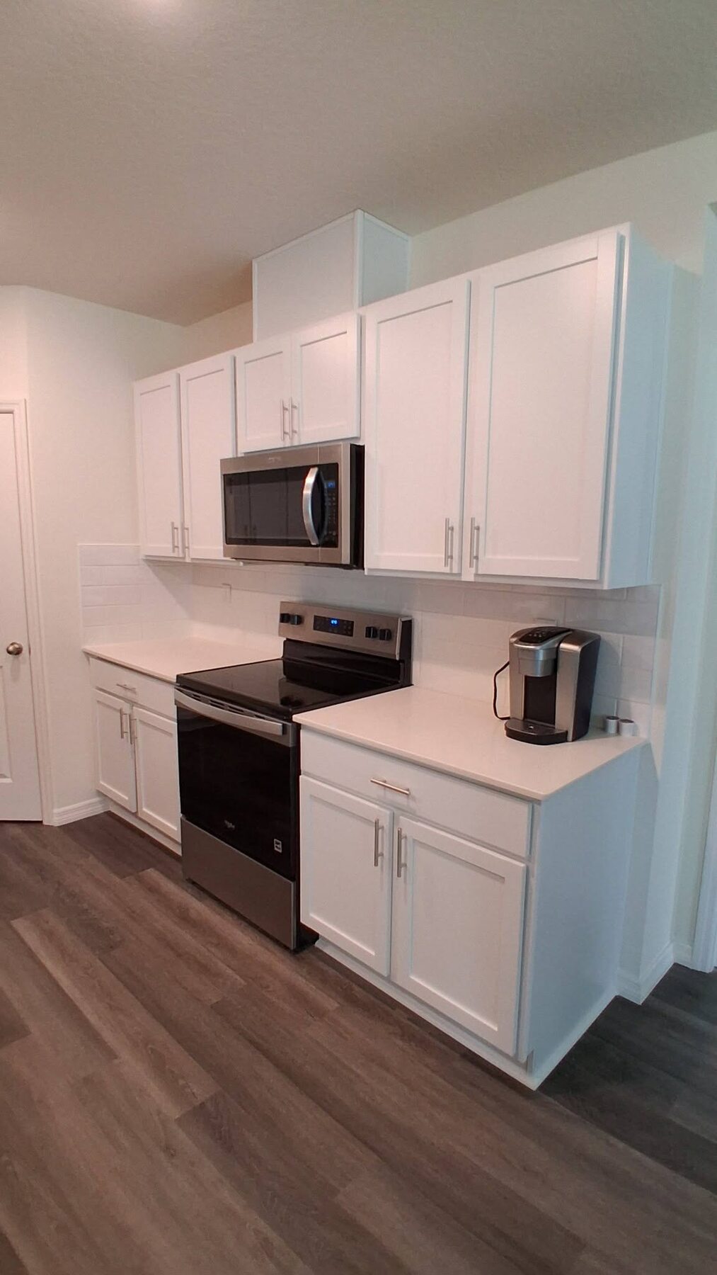 Freshly installed white kitchen cabinets by Dan's Service & Repair, LLC